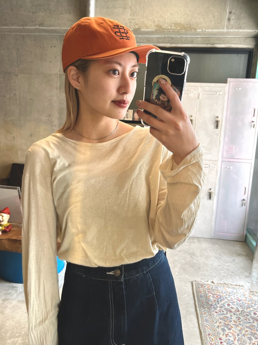 ブラック系のスニーカー、ブルー系のスカート、ホワイト系のTシャツ/カットソーを着用したレディースの春コーディネートの3枚目の写真