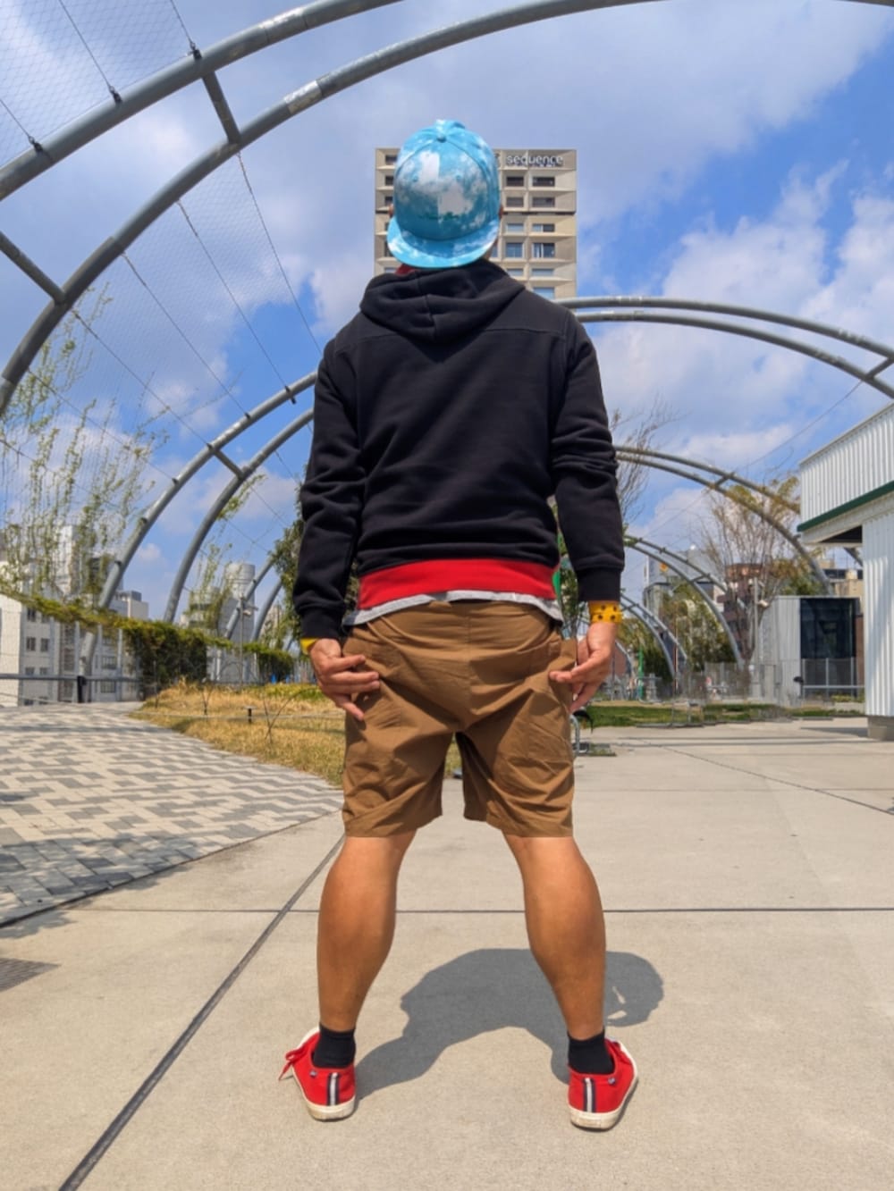 レッド系のスニーカー、ベージュ系のカーゴパンツ、その他のパーカーを着用したメンズの春コーディネートの2枚目の写真