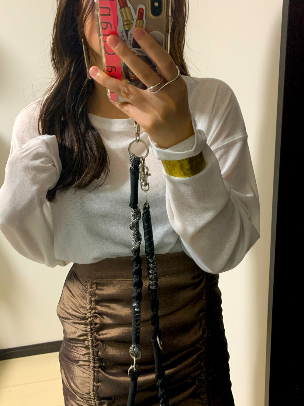 ブラウン系のスカート、ブラック系のパンツを着用したレディースの秋コーディネートの2枚目の写真