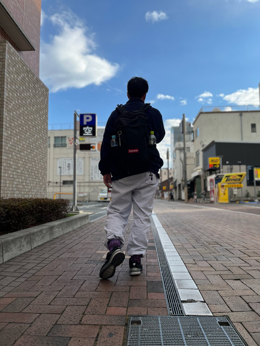 ブルー系のジャケット/アウター、ブラック系のバックパック/リュック、グレー系のスウェットパンツを着用したメンズの春コーディネートの2枚目の写真