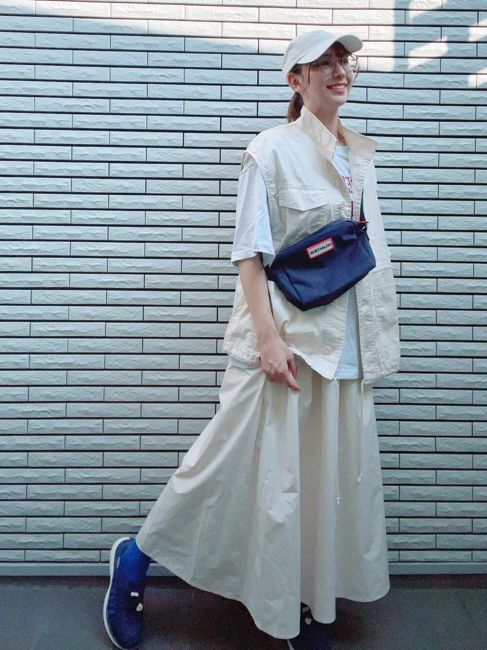 ホワイト系のベスト、グレー系のTシャツ/カットソー、ホワイト系のスカートを着用したレディースの夏コーディネートの4枚目の写真