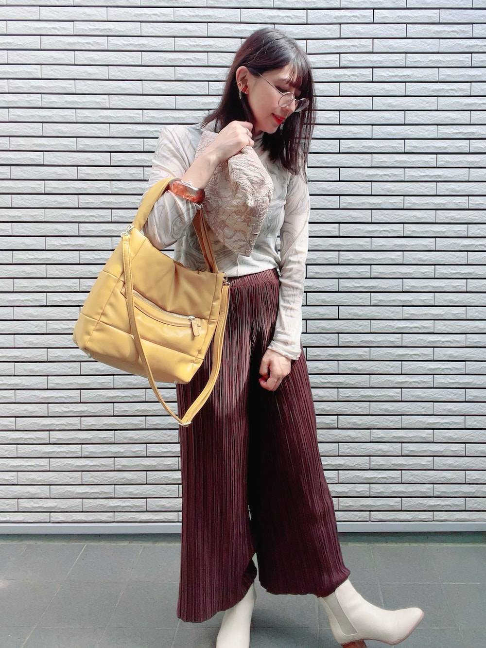 グリーン系のTシャツ/カットソー、イエロー系のトートバッグ、ホワイト系のブーツを着用したレディースの秋コーディネートの3枚目の写真