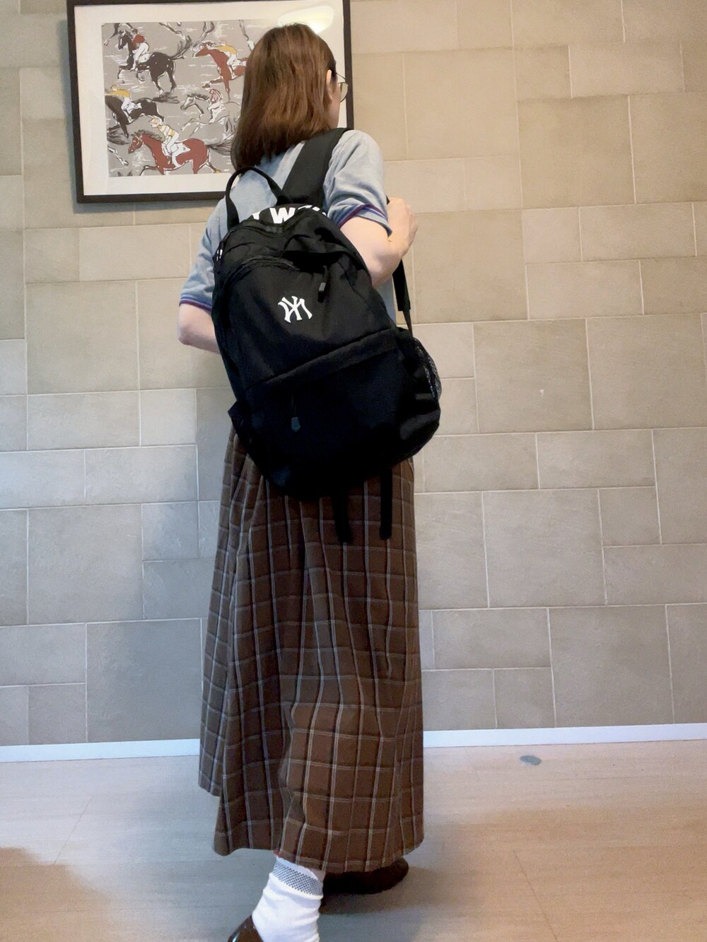 グレー系のポロシャツ、ブラック系のバックパック/リュック、その他のスカートを着用したレディースの夏コーディネートの3枚目の写真