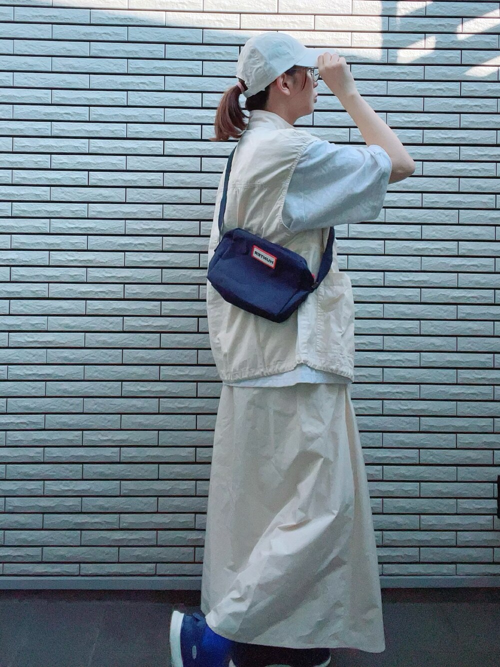 ホワイト系のベスト、グレー系のTシャツ/カットソー、ホワイト系のスカートを着用したレディースの夏コーディネートの3枚目の写真