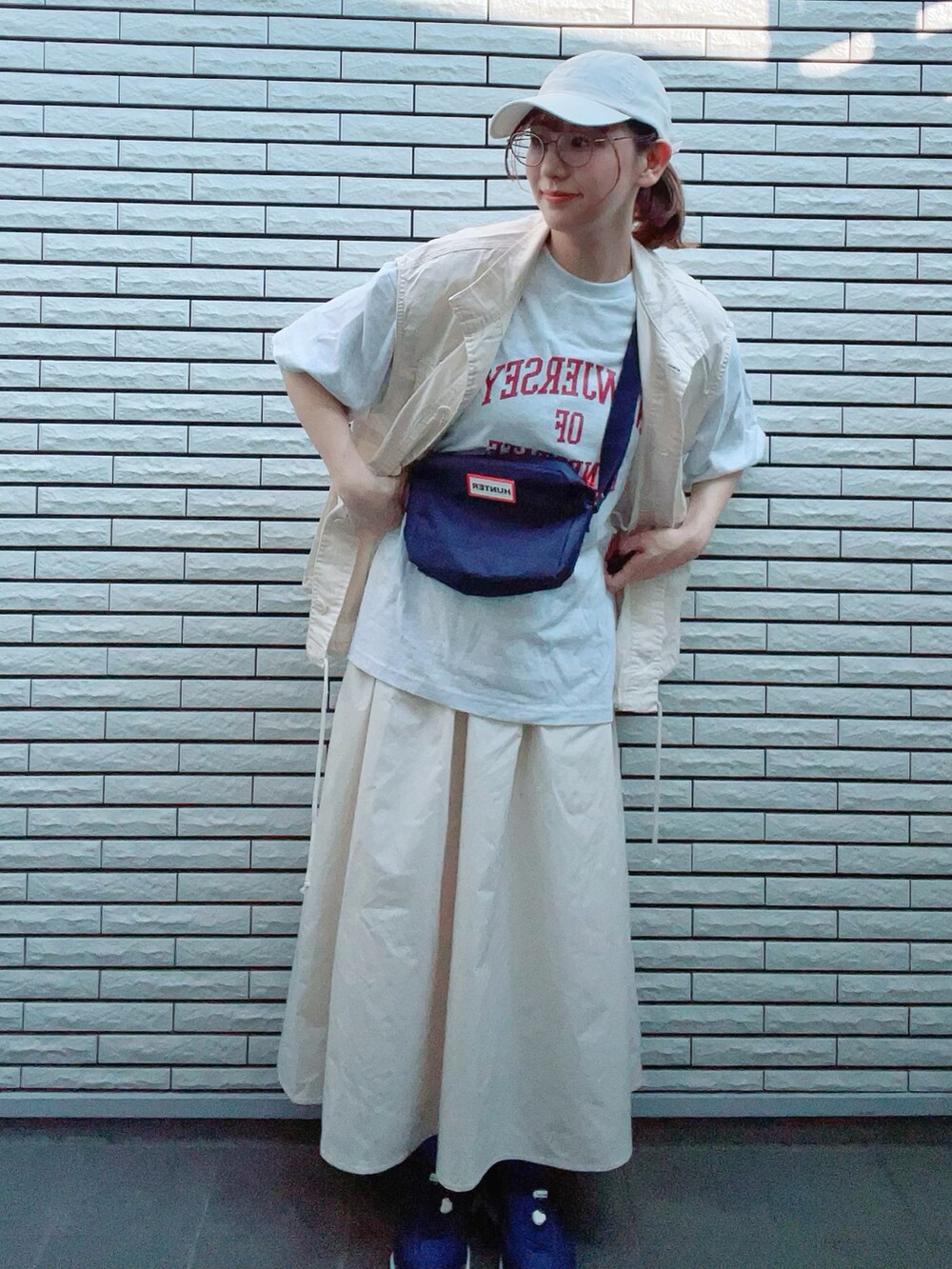 ホワイト系のベスト、グレー系のTシャツ/カットソー、ホワイト系のスカートを着用したレディースの夏コーディネートの2枚目の写真