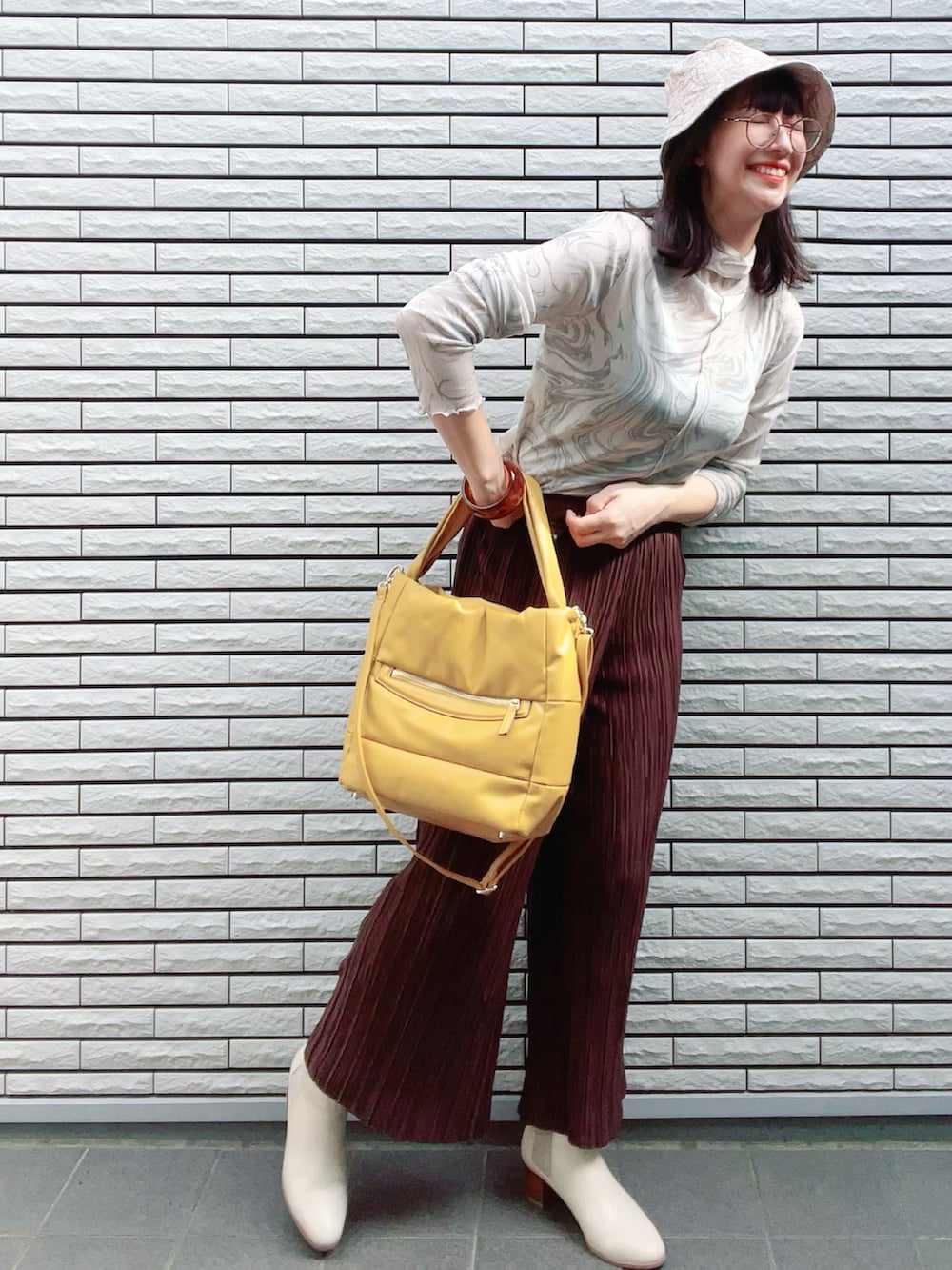 グリーン系のTシャツ/カットソー、イエロー系のトートバッグ、ホワイト系のブーツを着用したレディースの秋コーディネートの2枚目の写真