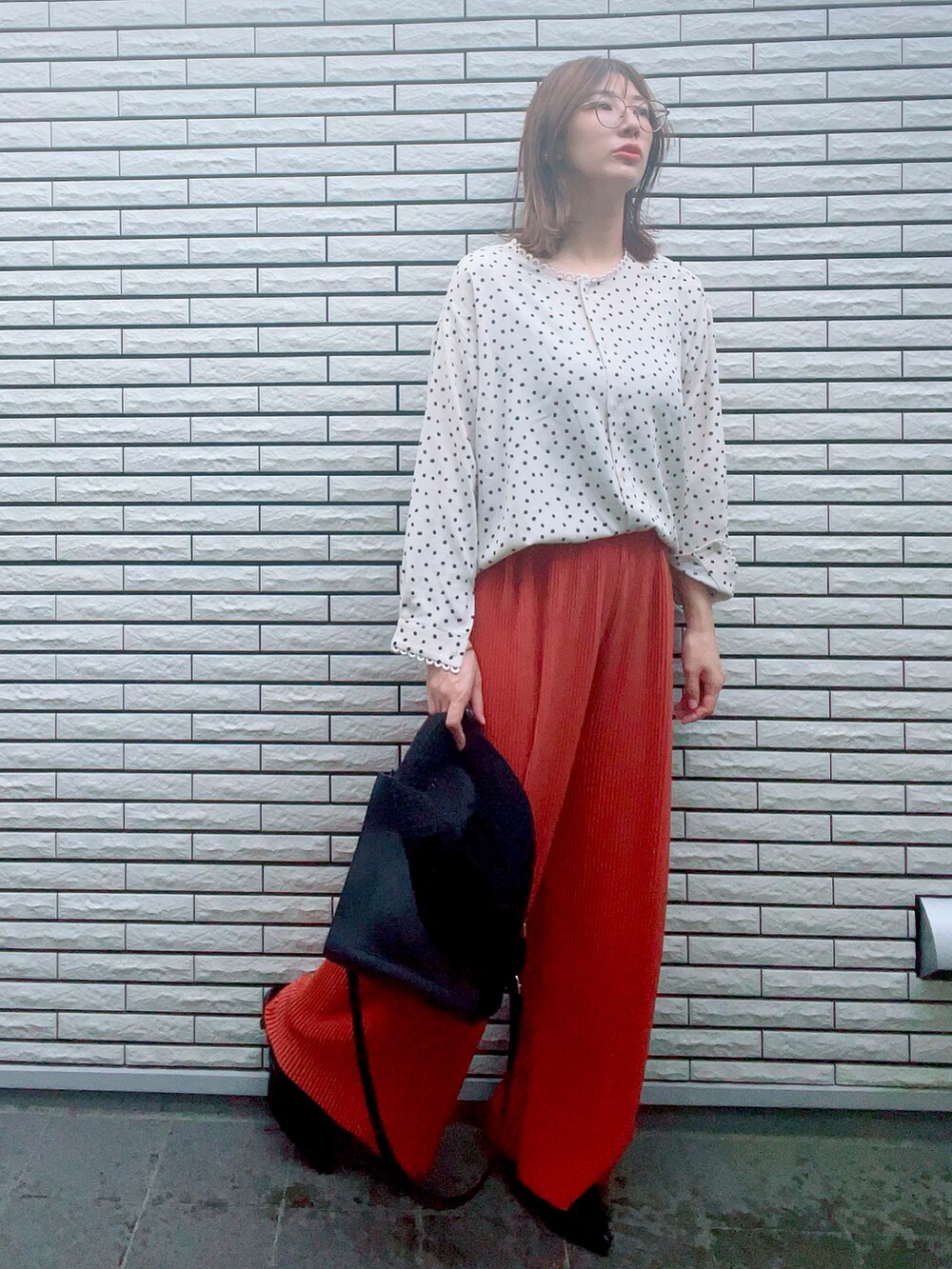 オレンジ系のパンツ、ブラック系のトートバッグ、ブラック系のサンダルを着用したレディースの夏コーディネートの3枚目の写真