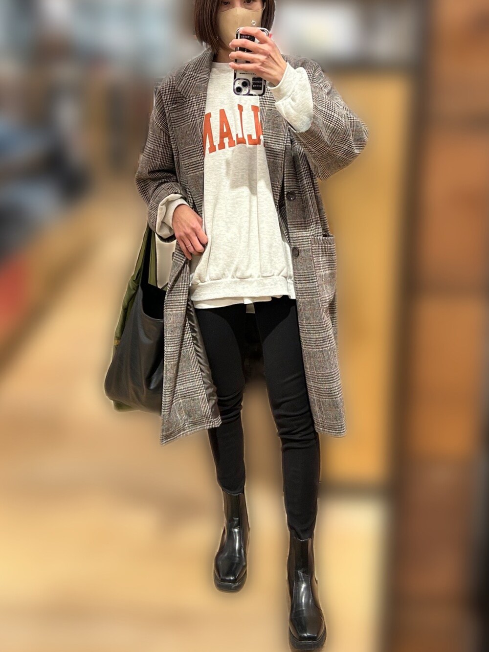 グレー系のチェスターコート、ブラック系のブーツ、ブラック系のその他パンツを着用したレディースの冬コーディネートの3枚目の写真