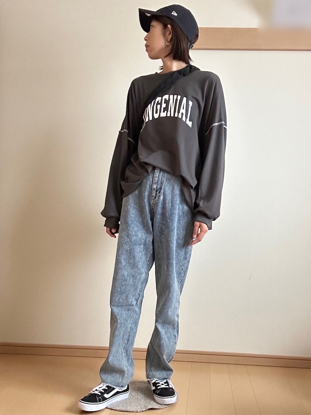 グレー系のTシャツ/カットソー、ブルー系のデニムパンツ、ブラック系のスニーカーを着用したレディースの春コーディネートの2枚目の写真