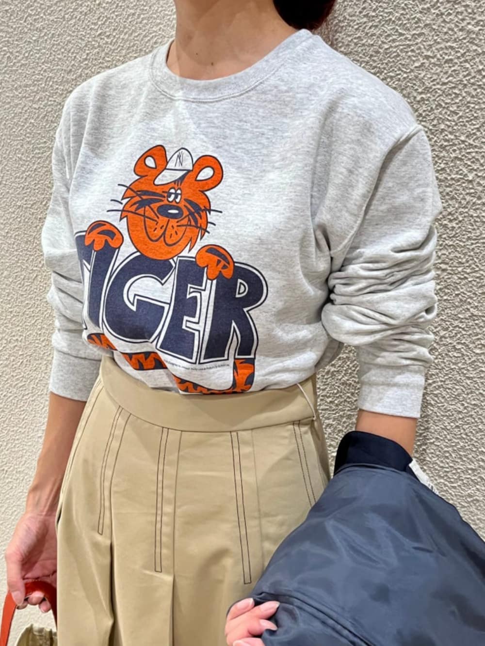 ブルー系のテーラードジャケット、ベージュ系のスカート、グレー系のTシャツ/カットソーを着用したレディースの秋コーディネートの2枚目の写真