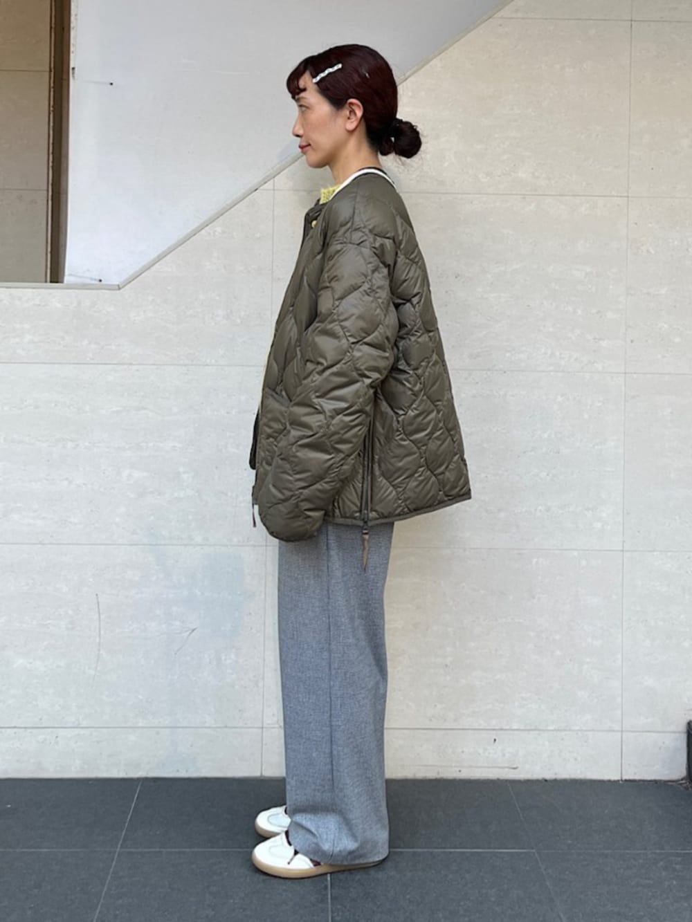 グリーン系のダウンジャケット/コート、ブラック系のその他パンツ、ホワイト系のショルダーバッグを着用したレディースの秋コーディネートの2枚目の写真