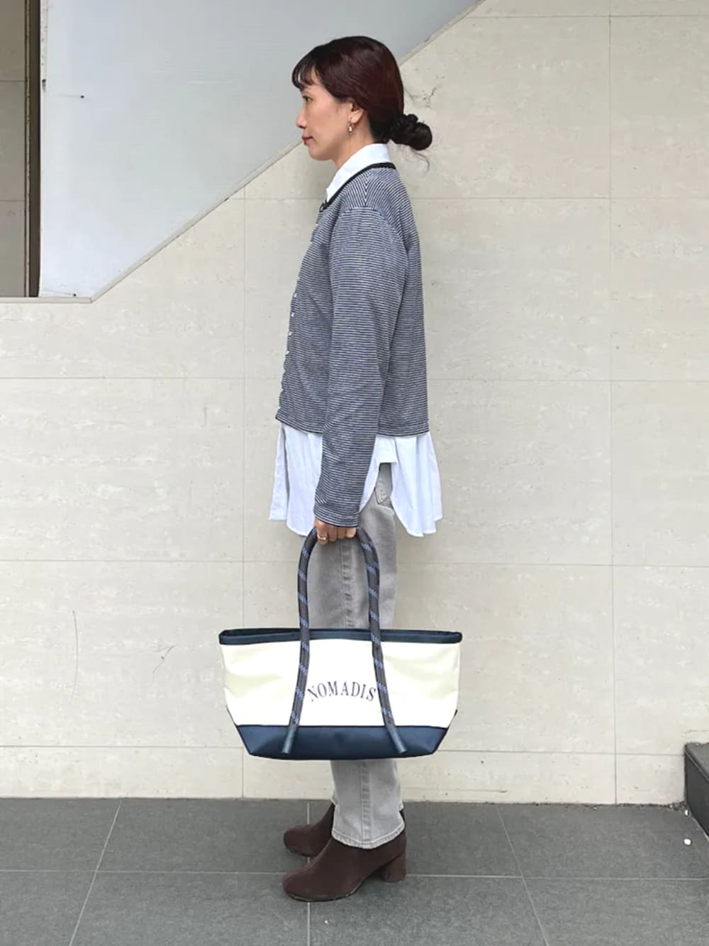 ホワイト系のシャツ/ブラウス、ブラウン系のブーツ、ブルー系のトートバッグを着用したレディースの春コーディネートの2枚目の写真