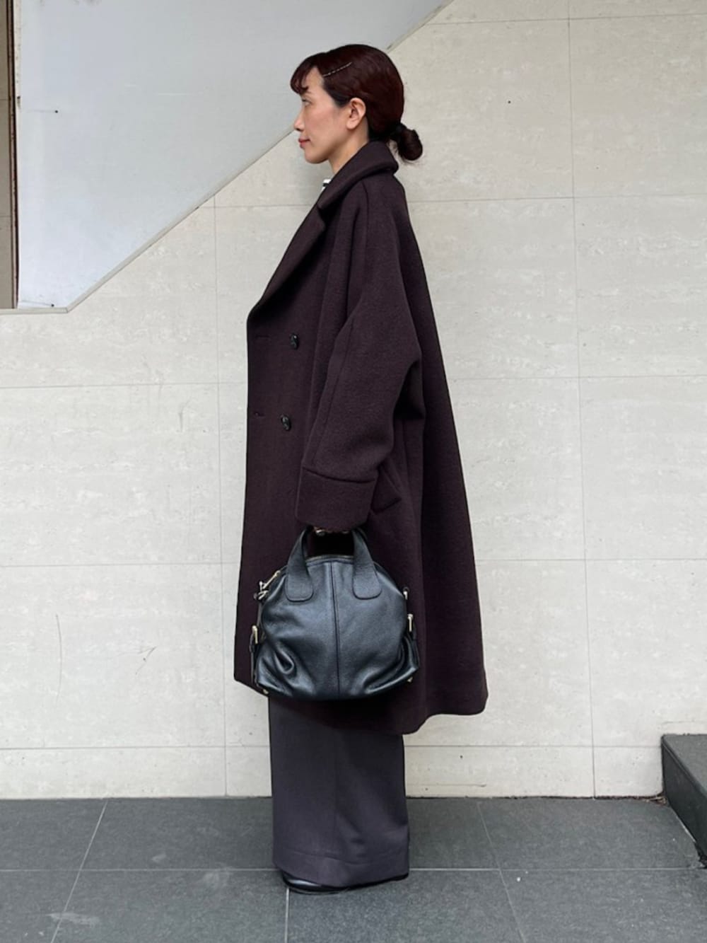 ブラック系のボストンバッグ、ブルー系のTシャツ/カットソー、ブラウン系のその他アウターを着用したレディースの秋コーディネートの2枚目の写真