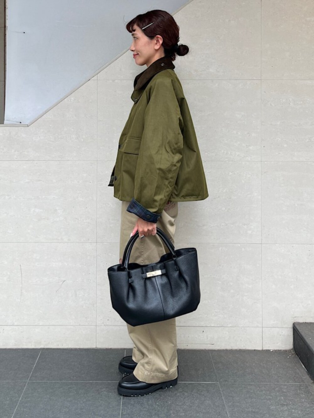 ベージュ系のチノパンツ、グリーン系のその他アウター、ブラック系のトートバッグを着用したレディースの秋コーディネートの2枚目の写真