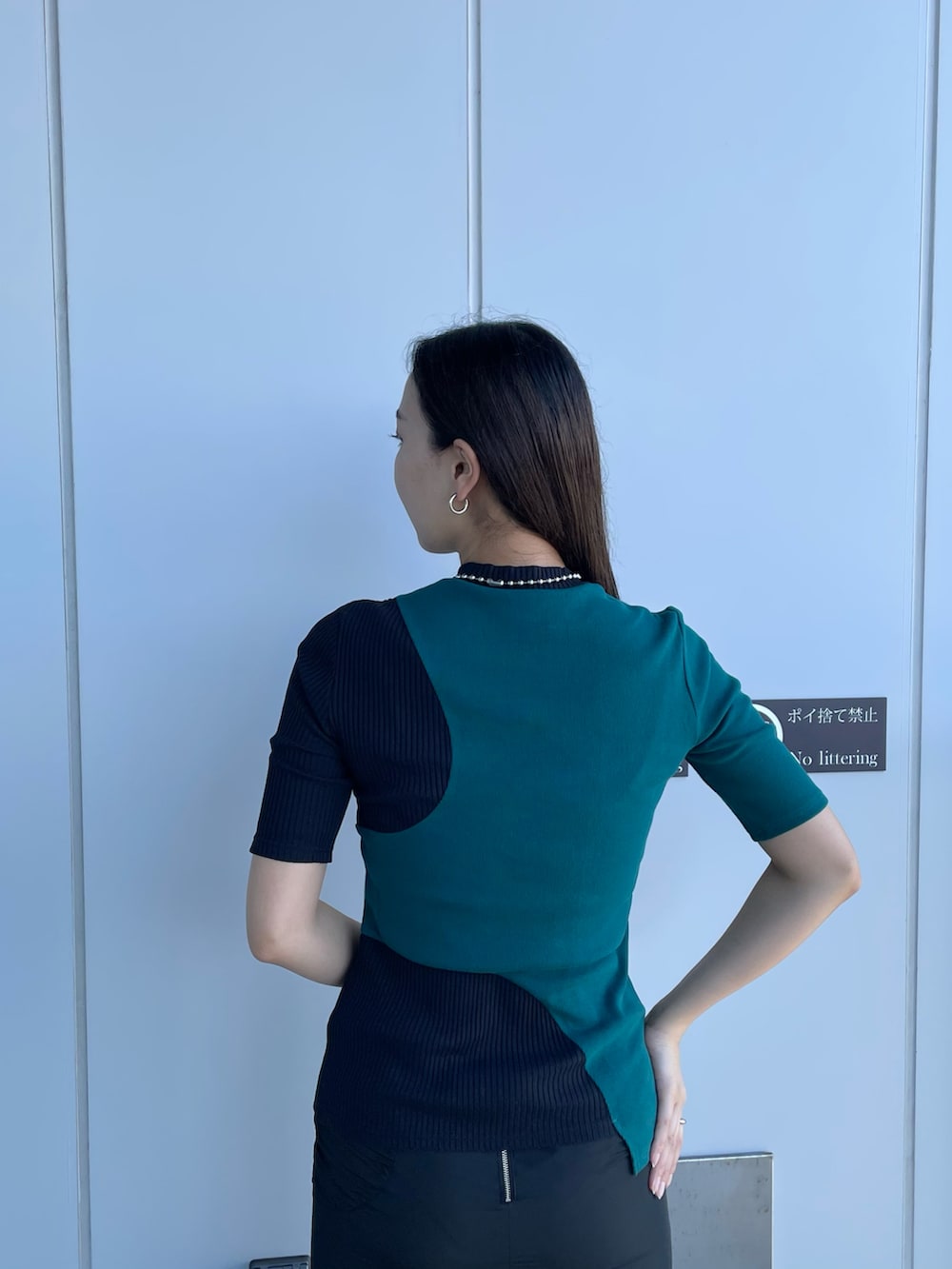 グリーン系のTシャツ/カットソー、ブラック系のスカート、ホワイト系のサンダルを着用したレディースの夏コーディネートの3枚目の写真