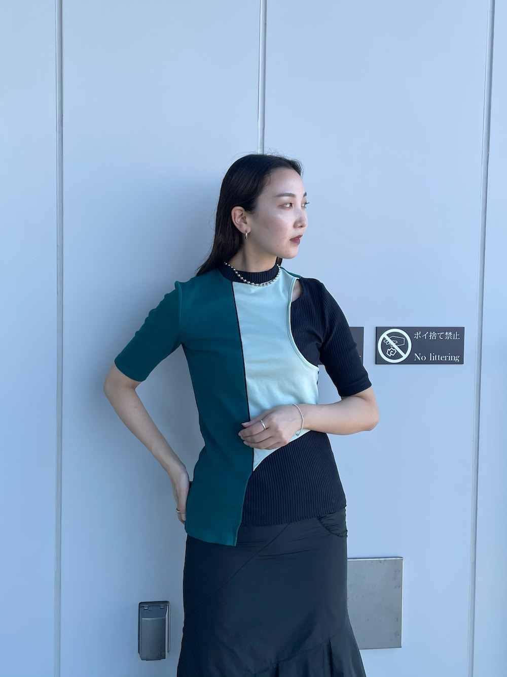 グリーン系のTシャツ/カットソー、ブラック系のスカート、ホワイト系のサンダルを着用したレディースの夏コーディネートの4枚目の写真