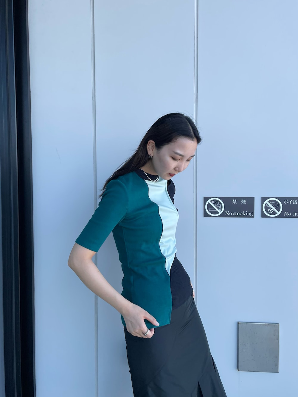 グリーン系のTシャツ/カットソー、ブラック系のスカート、ホワイト系のサンダルを着用したレディースの夏コーディネートの2枚目の写真