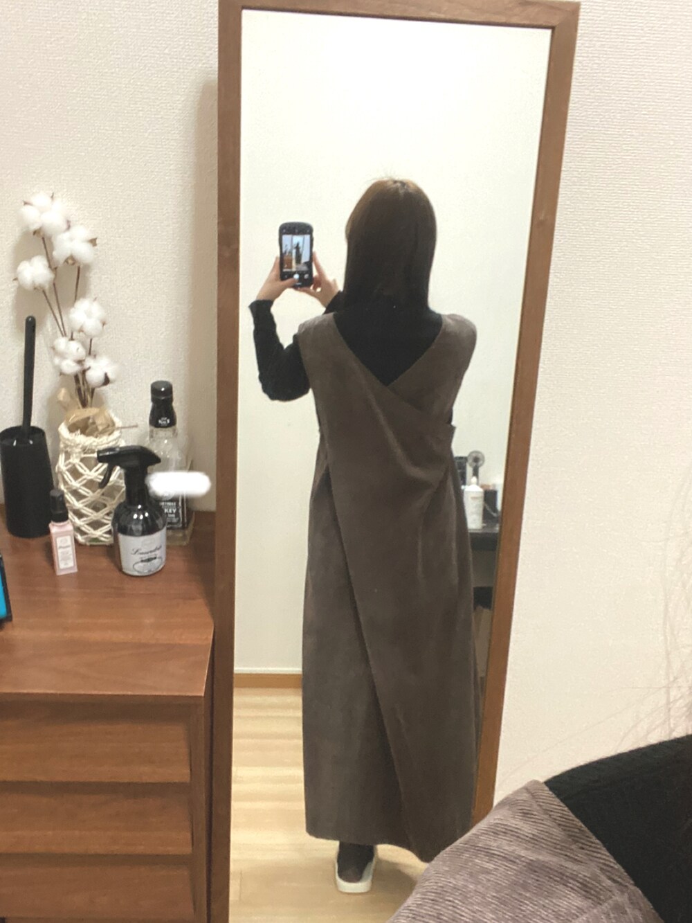 ブラウン系のワンピース、ブラック系のスニーカー、ブラック系のニット/セーターを着用したレディースの冬コーディネートの2枚目の写真