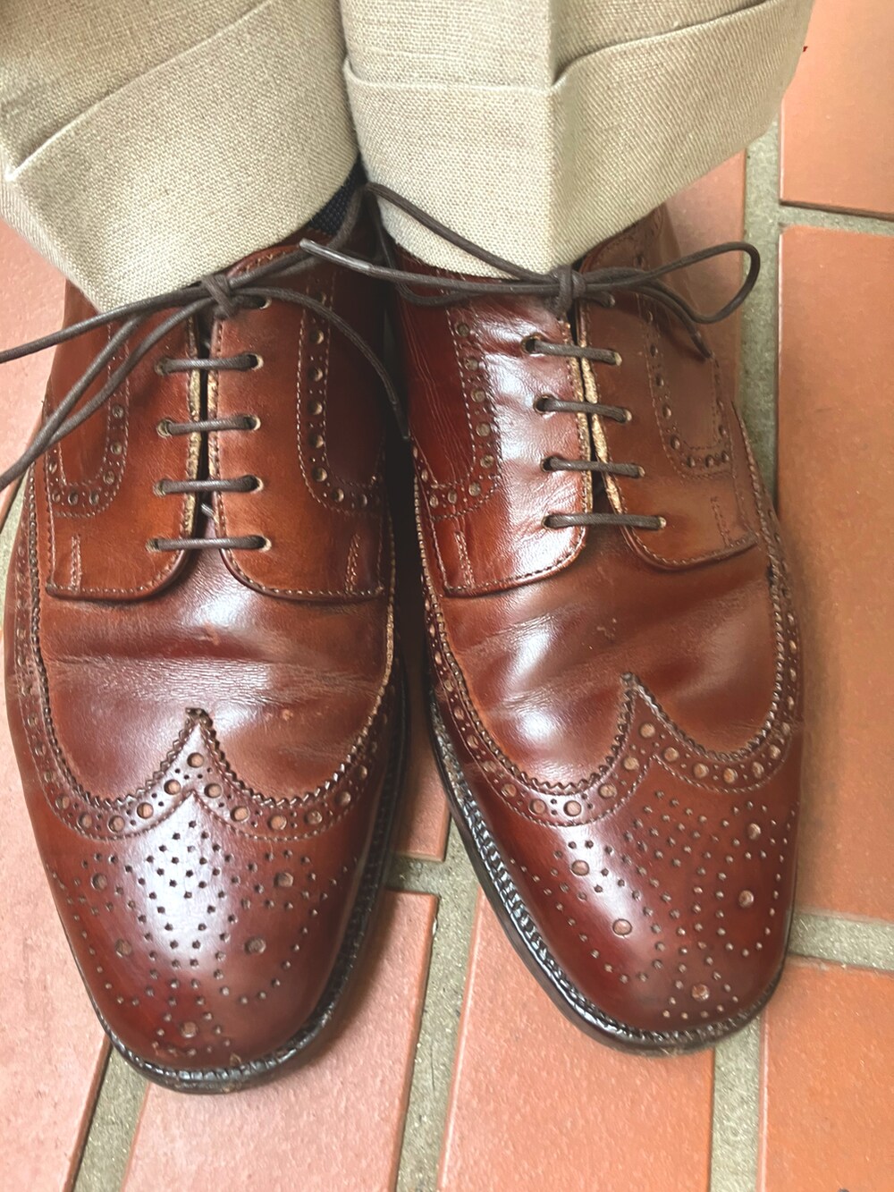 ブラウン系のドレスシューズ、レッド系のネクタイ、ホワイト系のシャツ/ブラウスを着用したメンズの夏コーディネートの2枚目の写真