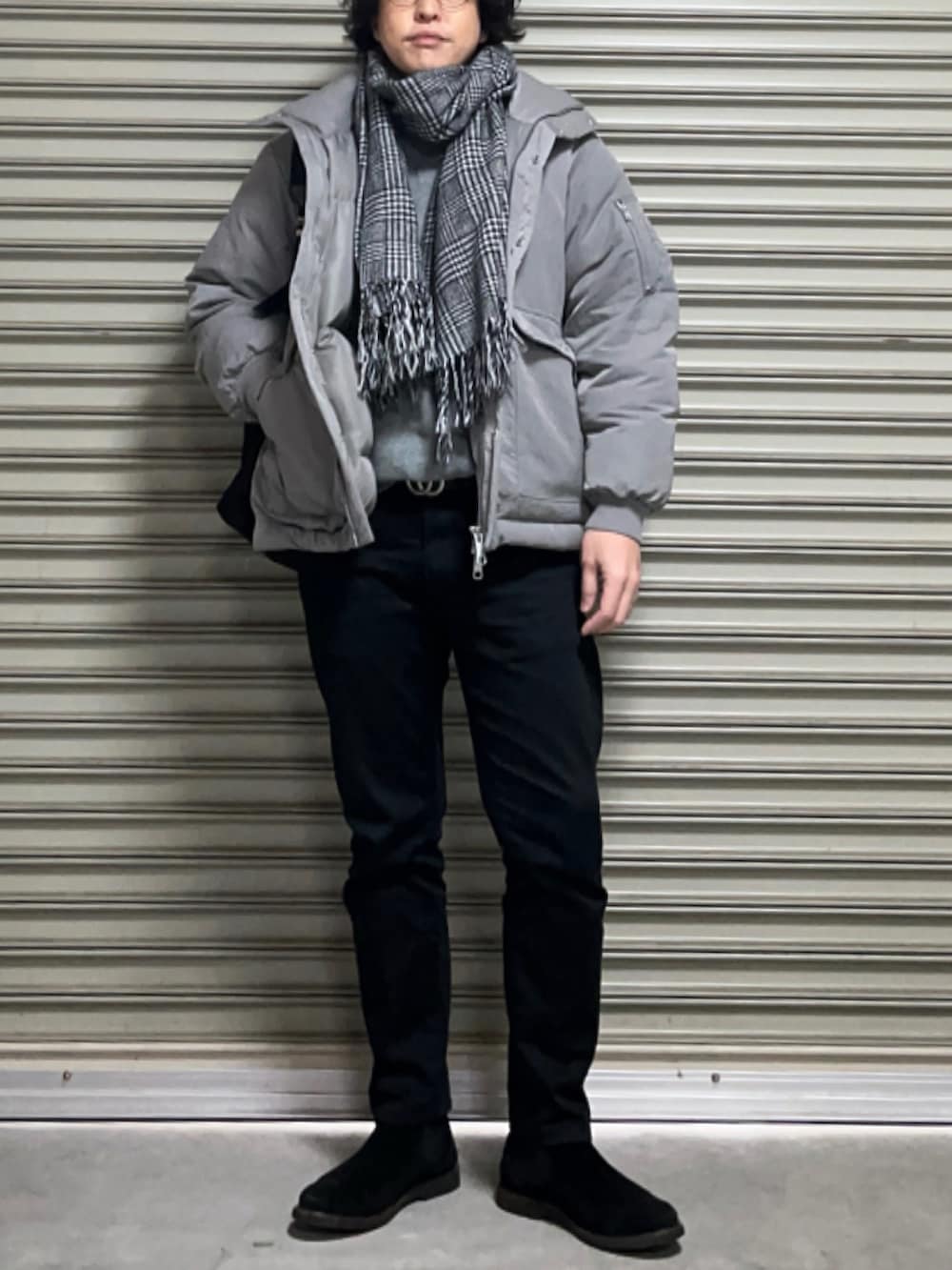 ブラック系のバックパック/リュック、グレー系のダウンジャケット/コート、ブラック系のチノパンツを着用したメンズの冬コーディネートの2枚目の写真