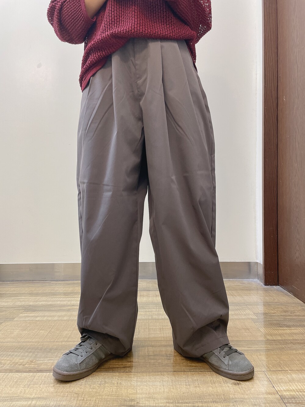 レッド系のニット/セーター、グレー系のその他パンツ、ベージュ系のキャップを着用したレディースの秋コーディネートの5枚目の写真
