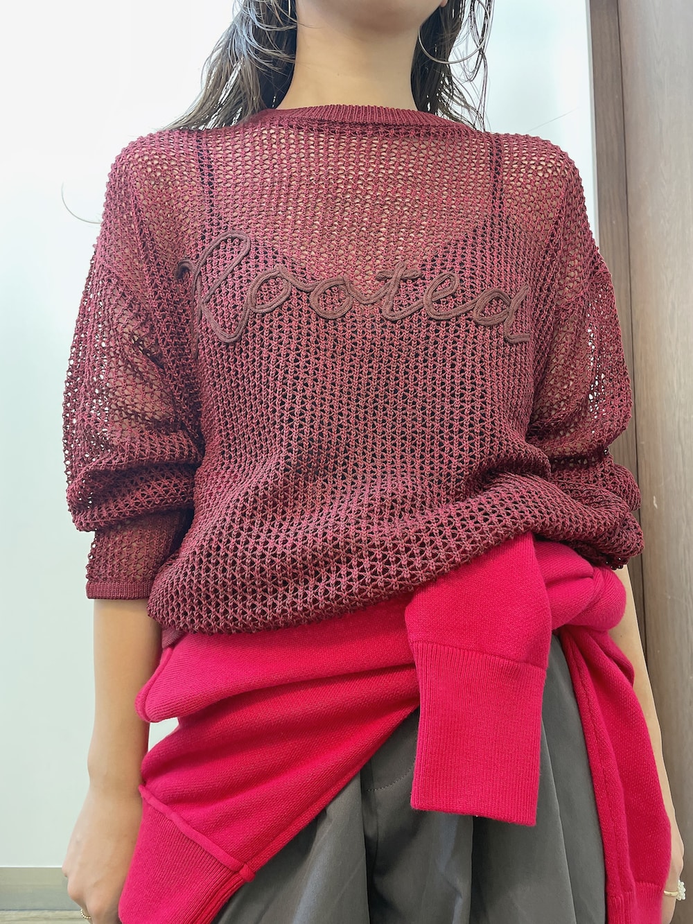 レッド系のニット/セーター、グレー系のその他パンツ、ベージュ系のキャップを着用したレディースの秋コーディネートの4枚目の写真