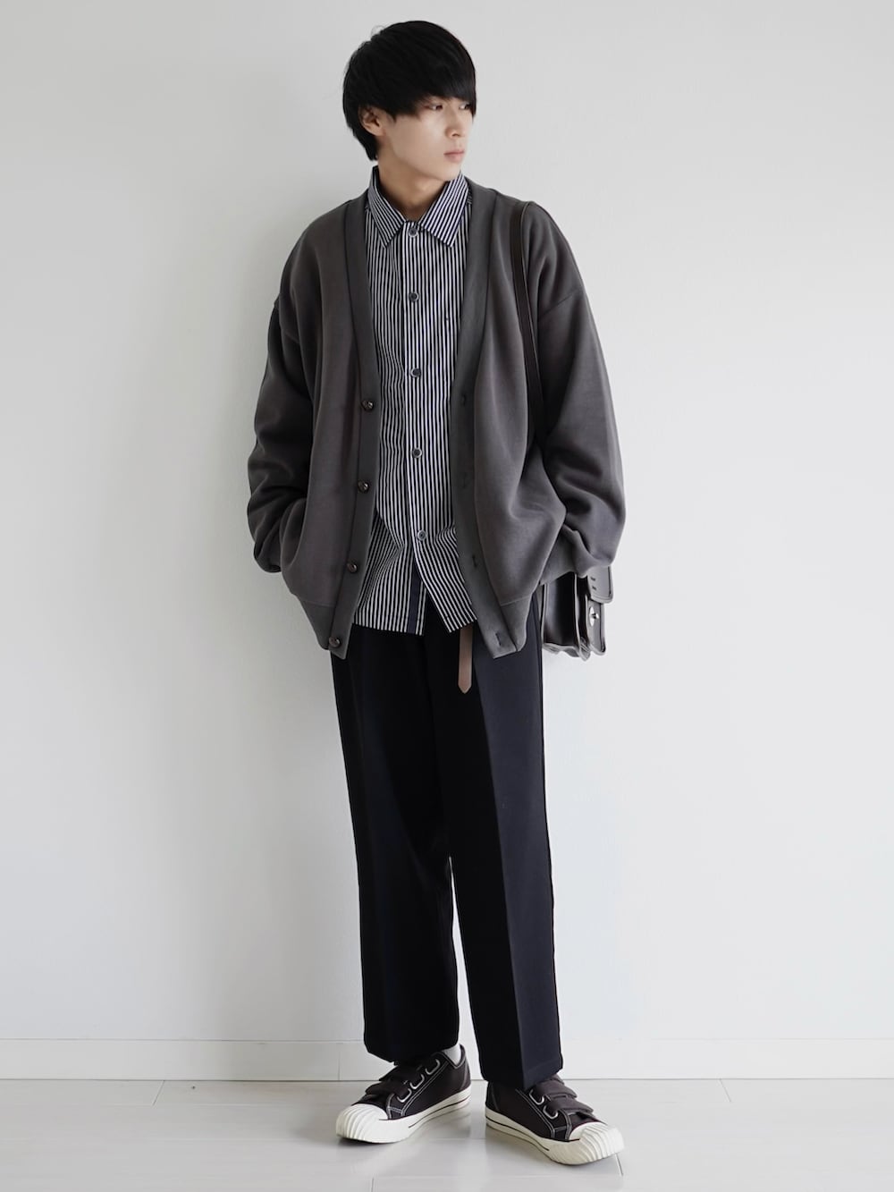 グレー系のカーディガン/ボレロ、ブラック系のシャツ/ブラウス、ブラック系のショルダーバッグを着用したメンズの冬コーディネートの2枚目の写真