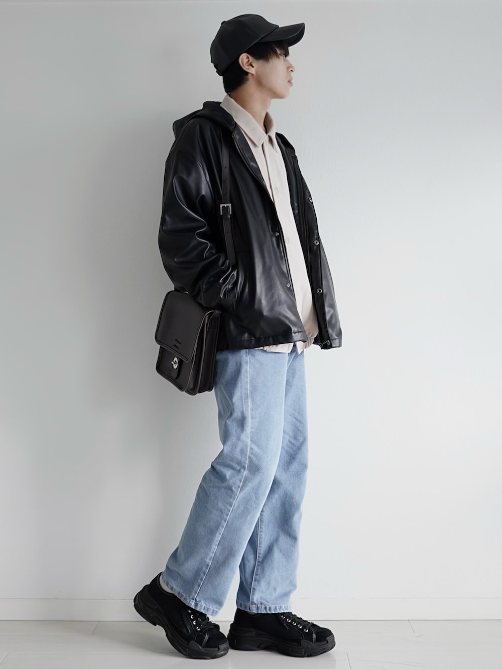ブルー系のデニムパンツ、ブラック系のブルゾン、ホワイト系のブルゾンを着用したメンズの春コーディネートの2枚目の写真