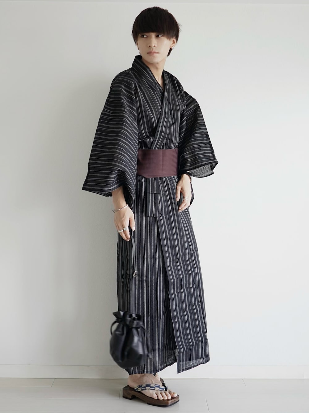 ブラック系の浴衣、シルバー系のイヤーカフ、ホワイト系のブレスレットを着用したメンズの夏コーディネートの2枚目の写真