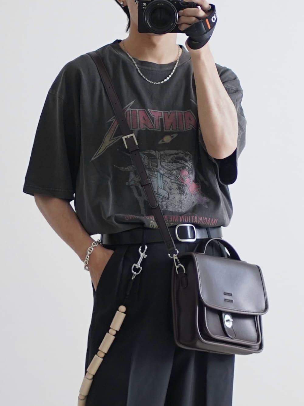 グレー系のTシャツ/カットソー、ブラック系のデニムパンツ、ブラウン系のショルダーバッグを着用したメンズの夏コーディネートの2枚目の写真