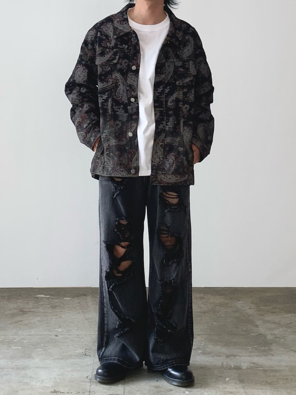 ブラック系のデニムジャケット、ブラック系のデニムパンツ、ブラック系のブーツを着用したメンズの秋コーディネートの2枚目の写真