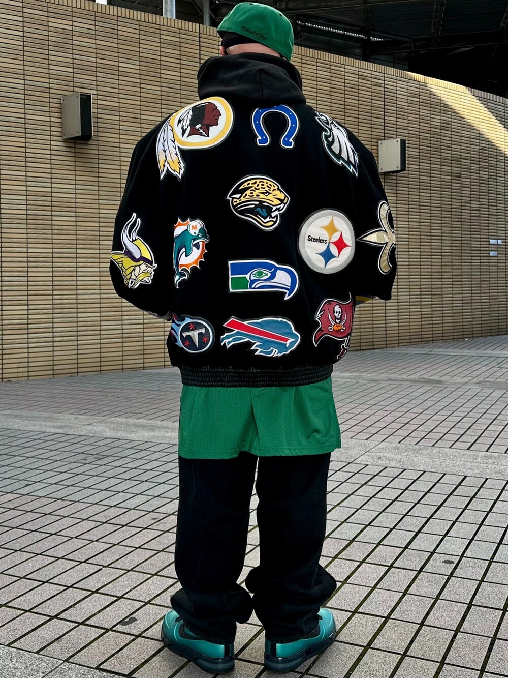 ブラック系のスタジャン、グリーン系のTシャツ/カットソー、ブラック系のデニムパンツを着用したメンズの冬コーディネートの2枚目の写真