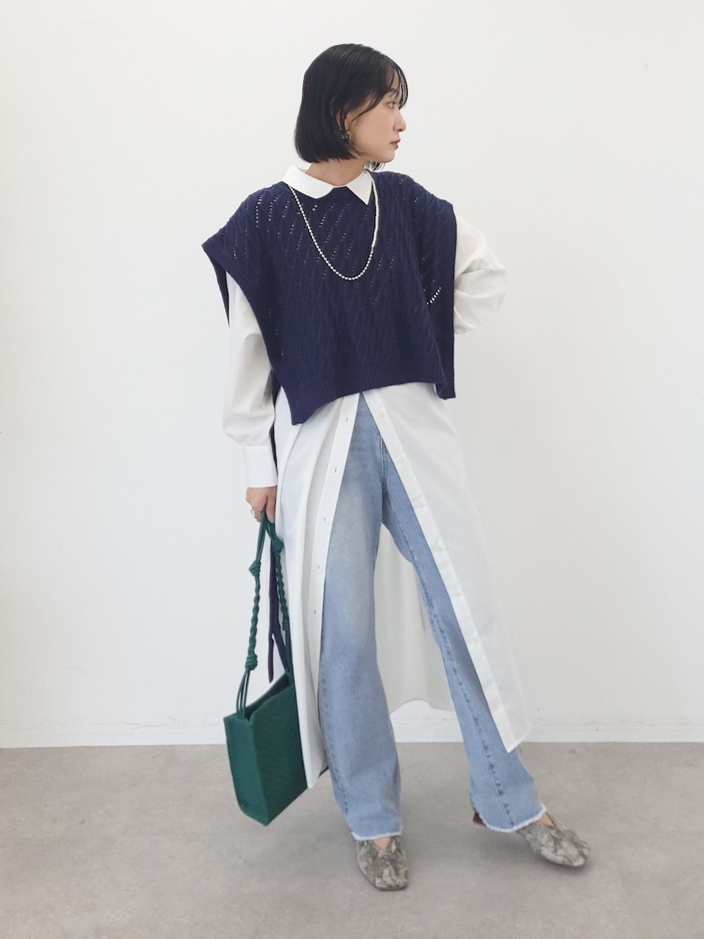ブルー系のベスト、ホワイト系のワンピース、ブルー系のデニムパンツを着用したレディースの夏コーディネートの4枚目の写真