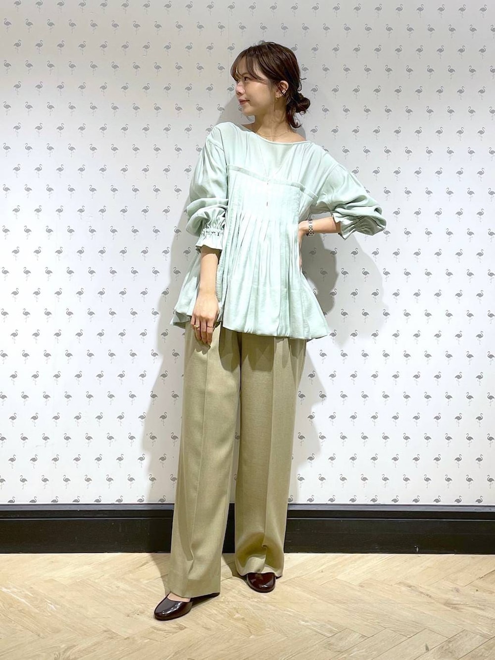 ベージュ系のスラックス、グリーン系のシャツ/ブラウス、レッド系のパンプスを着用したレディースの冬コーディネートの3枚目の写真