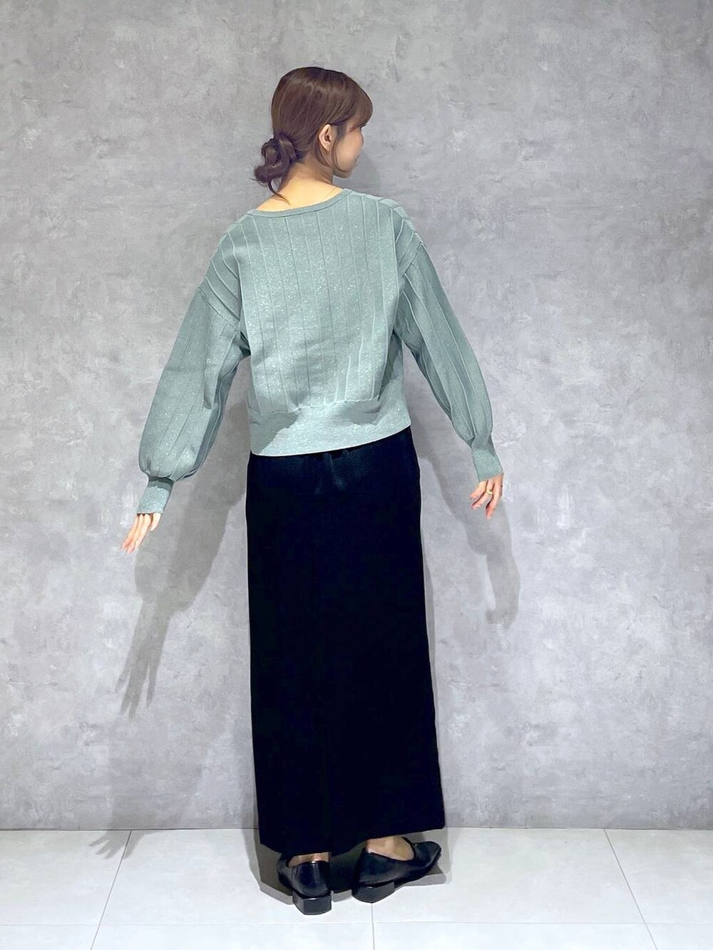 グリーン系のカーディガン/ボレロ、ブラック系のスカートを着用したレディースの春コーディネートの4枚目の写真