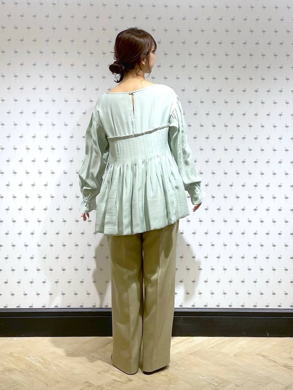 ベージュ系のスラックス、グリーン系のシャツ/ブラウス、レッド系のパンプスを着用したレディースの冬コーディネートの5枚目の写真