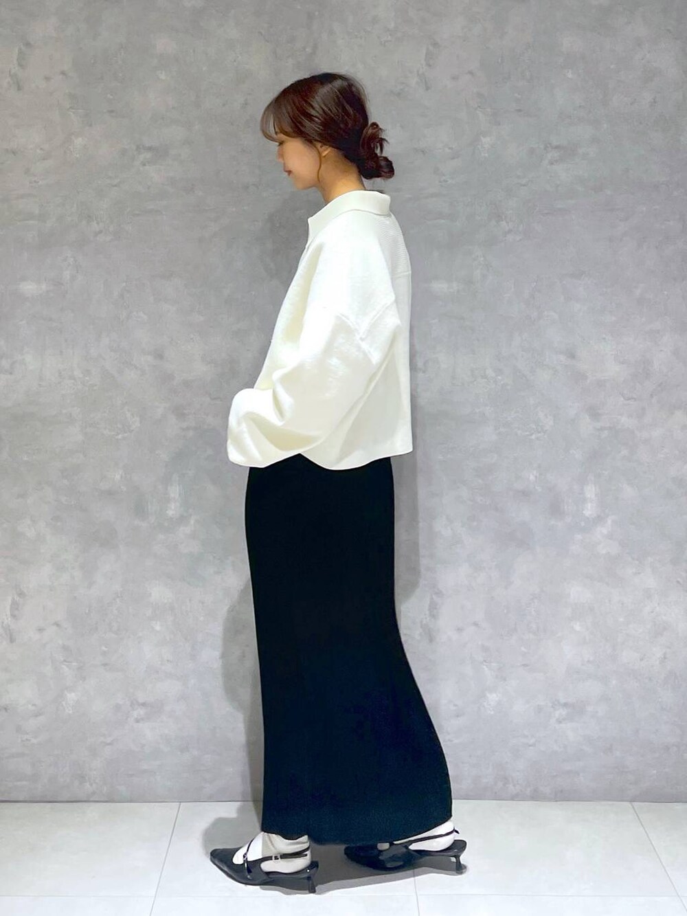 ブラック系のパンプス、ブラック系のスカート、ホワイト系のTシャツ/カットソーを着用したレディースの春コーディネートの3枚目の写真