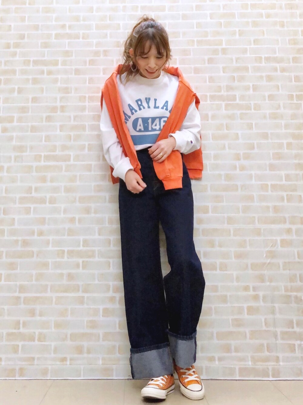 オレンジ系のTシャツ/カットソー、ホワイト系のTシャツ/カットソー、ベージュ系のショルダーバッグを着用したレディースの春コーディネートの2枚目の写真