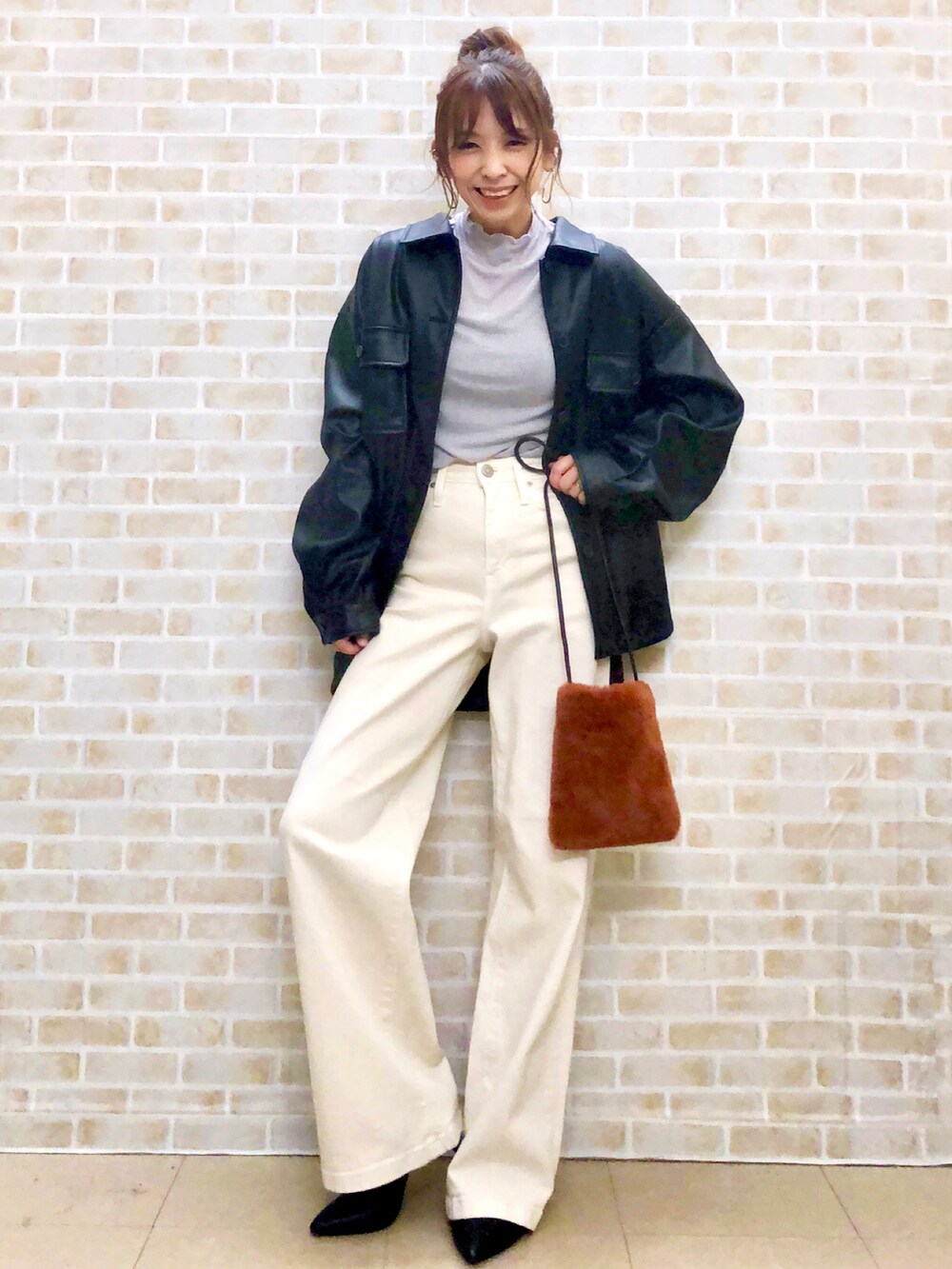 ブラック系のシャツ/ブラウス、グレー系のTシャツ/カットソー、ホワイト系のデニムパンツを着用したレディースの秋コーディネートの4枚目の写真