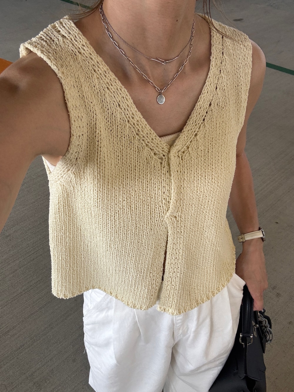 イエロー系のベストを着用したレディースの夏コーディネートの3枚目の写真