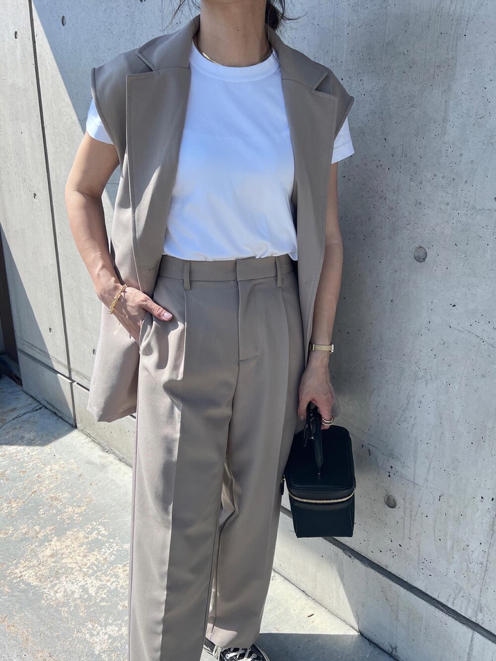 ベージュ系のセットアップ、ブラック系のバッグを着用したレディースの春コーディネートの3枚目の写真