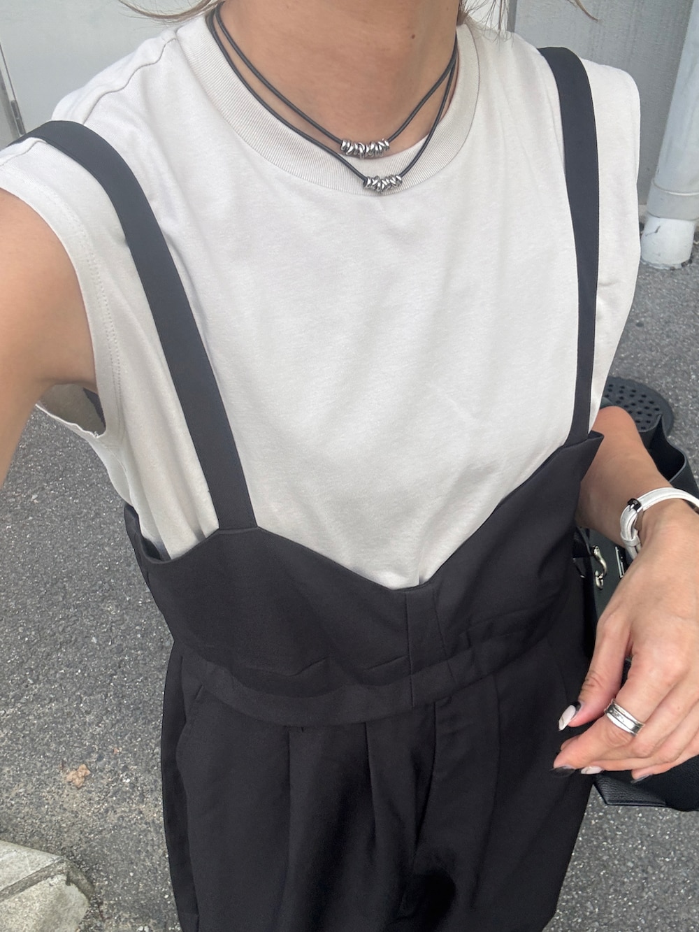 ブラック系のオールインワン・サロペットを着用したレディースの夏コーディネートの2枚目の写真