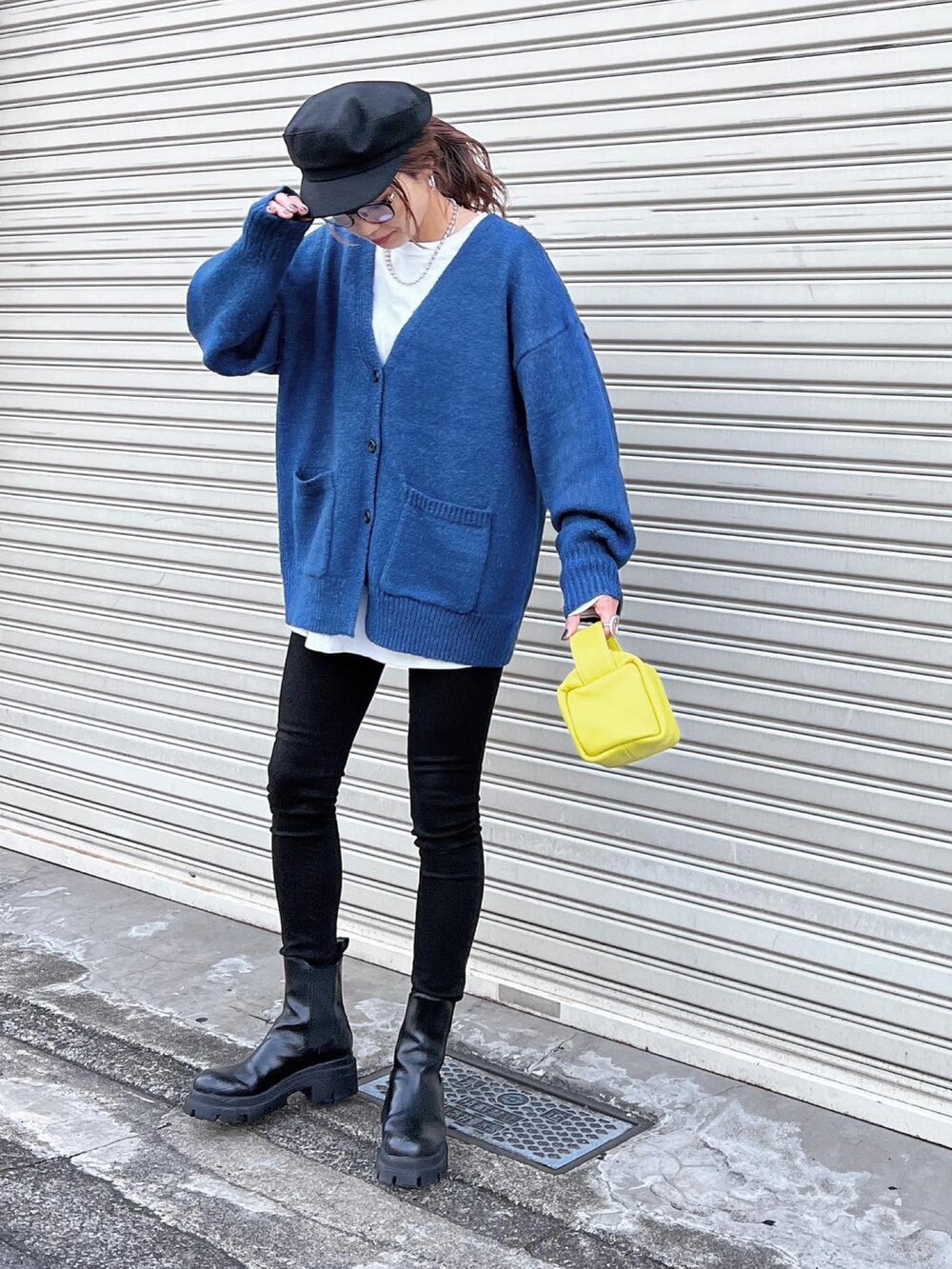 ブルー系のカーディガン/ボレロ、ブラック系のブーツ、イエロー系のバッグを着用したレディースの秋コーディネートの3枚目の写真