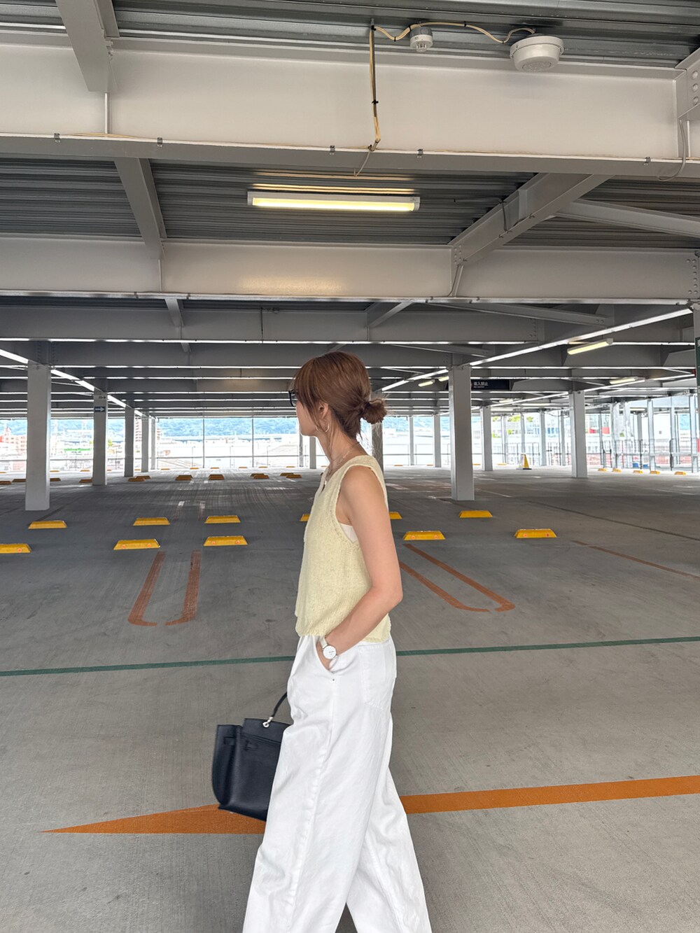 イエロー系のベストを着用したレディースの夏コーディネートの2枚目の写真