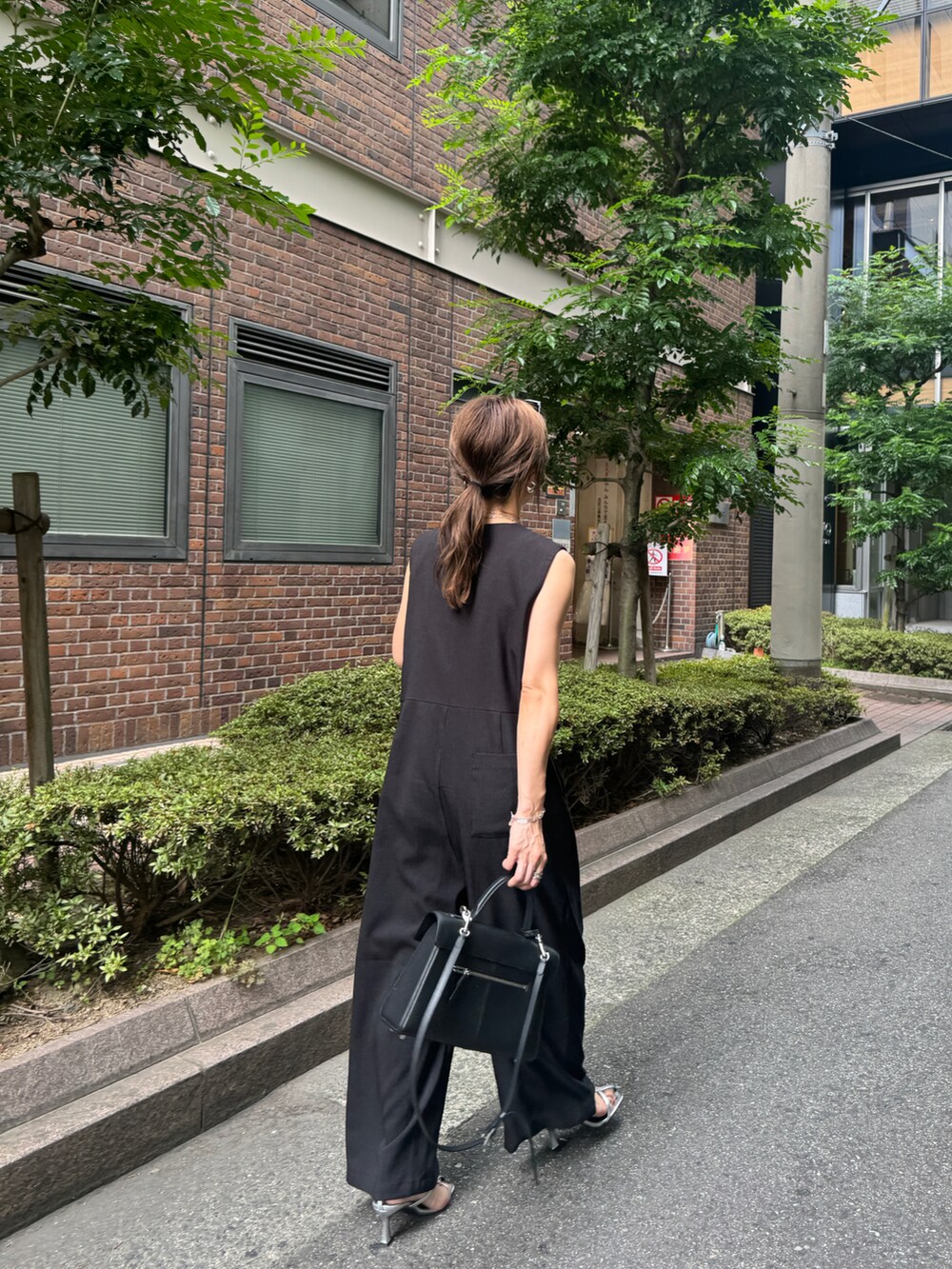 ブラック系のつなぎ/オールインワンを着用したレディースの夏コーディネートの2枚目の写真