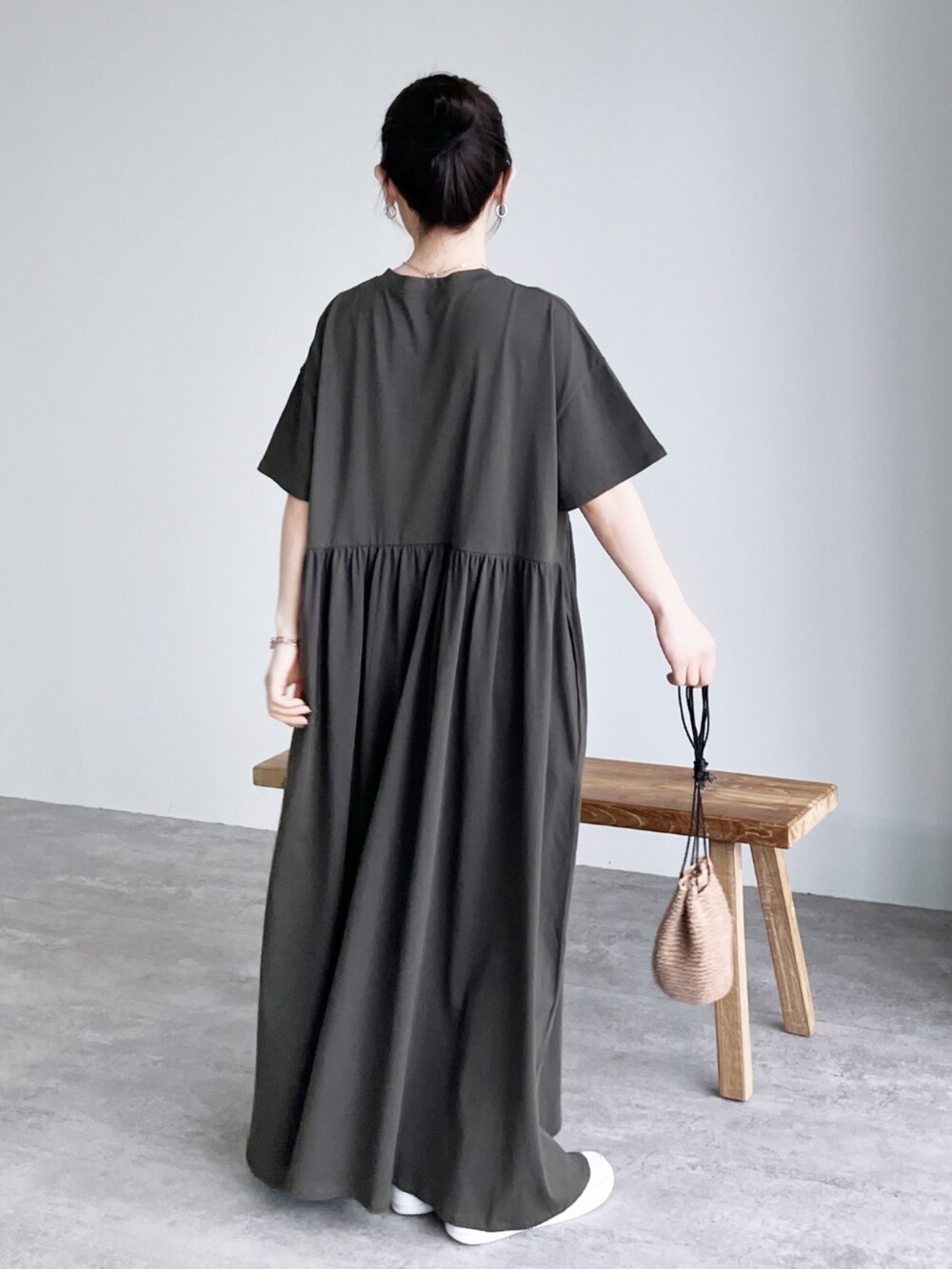 グレー系のワンピース、グリーン系のハンドバッグを着用したレディースの夏コーディネートの2枚目の写真