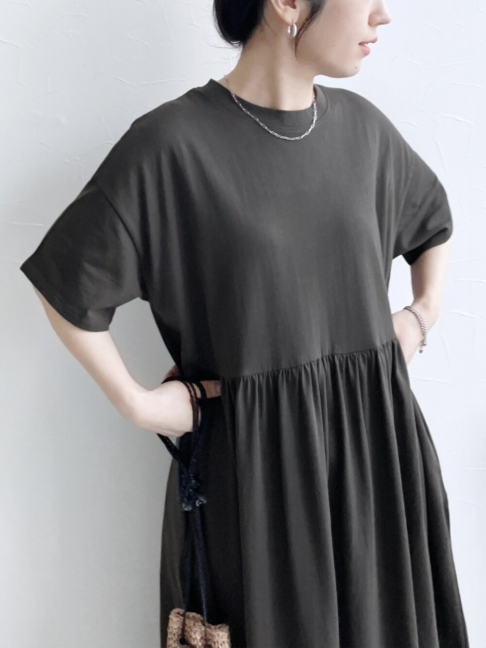 グレー系のワンピース、グリーン系のハンドバッグを着用したレディースの夏コーディネートの3枚目の写真