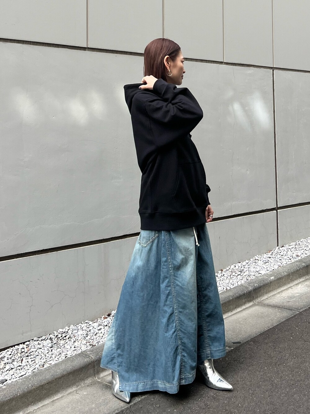 ブラック系のパーカー、シルバー系のブーツを着用したレディースの春コーディネートの3枚目の写真
