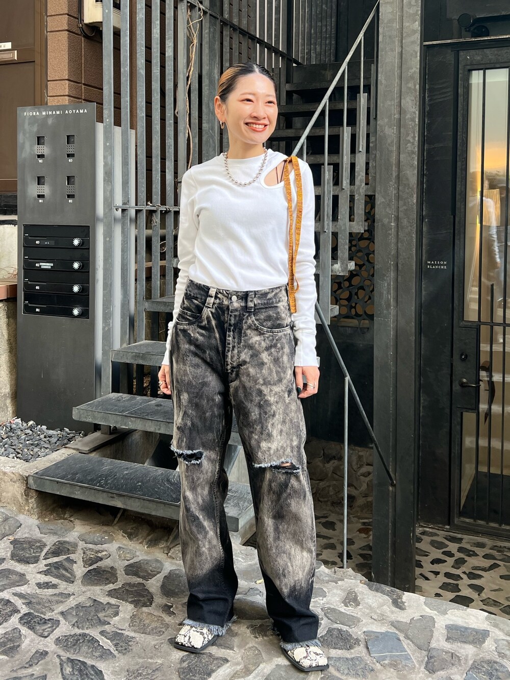 ブラック系のデニムパンツ、ホワイト系のTシャツ/カットソーを着用したレディースの冬コーディネートの2枚目の写真