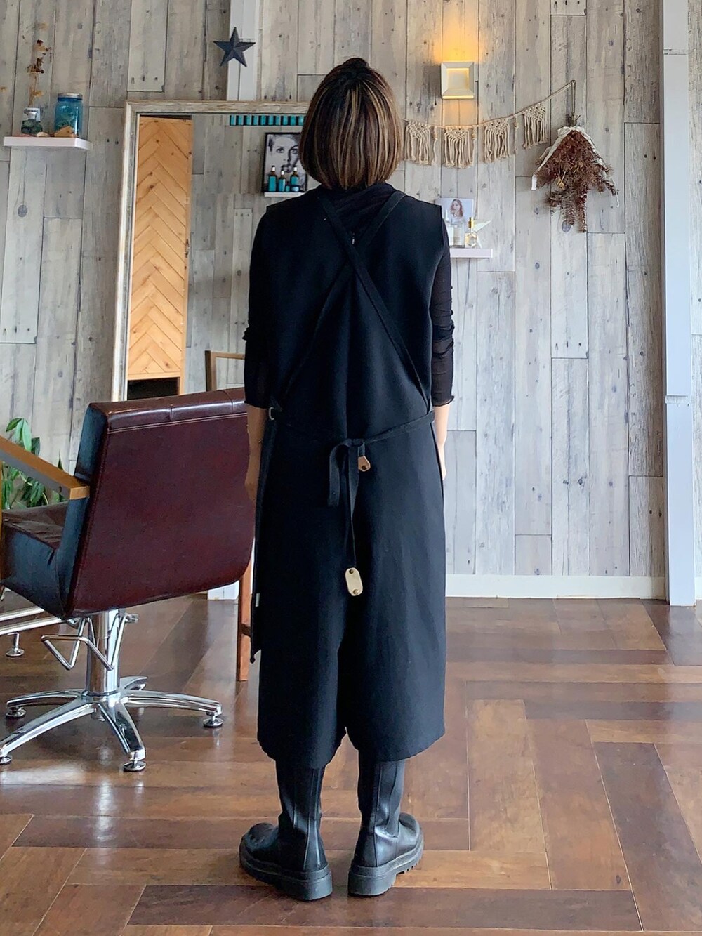 ブラック系のブーツ、ブラック系のTシャツ/カットソー、ゴールド系のイヤーカフを着用したレディースの夏コーディネートの2枚目の写真